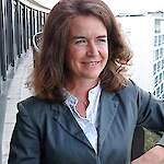 A middle-aged woman with shoulder-length brown hair, smiling softly.